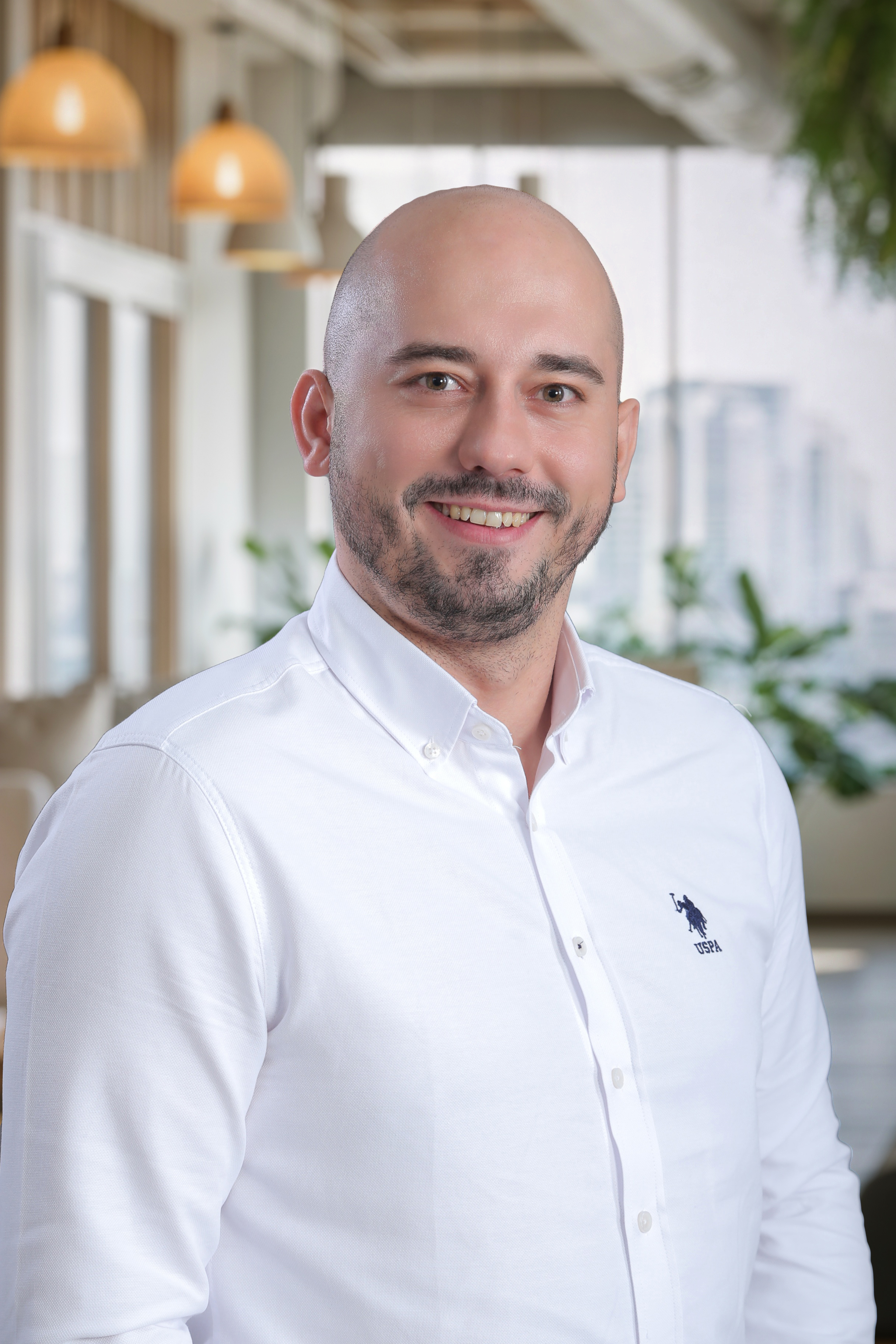 Sandy Smajic, founder, smiling in a white shirt